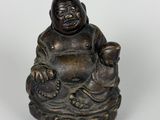 statue d'un Bouddha souriant assis sur un rocher avec un enfant