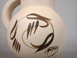 a white vase with a brown design on it