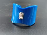 a close up of a blue ring with a diamond on it