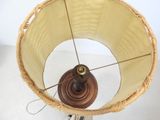 a wicker lamp shade with a wooden base on a stand