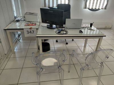 un bureau en verre sur lequel est posé un ordinateur