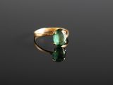 a close up of a gold ring with a green stone