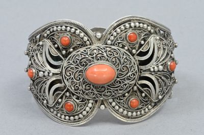 un gros plan sur un bracelet en argent orné de pierres de corail