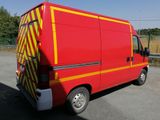 a red van with yellow stripes parked on the side of the road