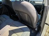 the back seat of a car with a black seat belt and a gray seat cover
