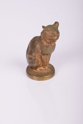 une petite statue représentant un chat assis sur une table