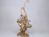 sculpture en bronze représentant une femme assise sur une branche ornée de fleurs