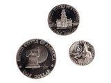 three coins are shown on a white surface with a white background