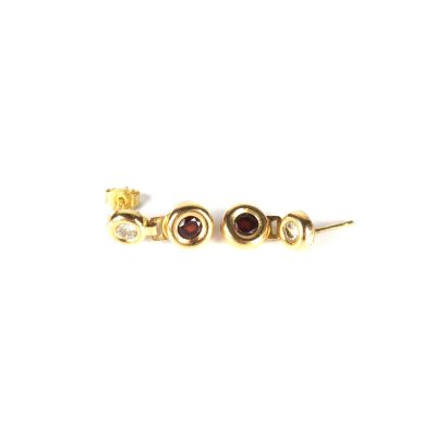gros plan d'une paire de boucles d'oreilles sur une surface blanche
