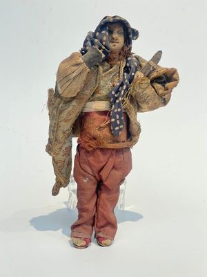 figurine représentant une femme portant un chapeau et une écharpe, tenant un téléphone portable