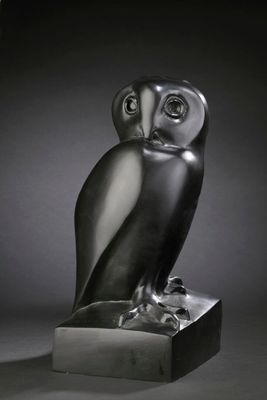 photographie en noir et blanc d'une statue représentant un hibou perché sur un bloc