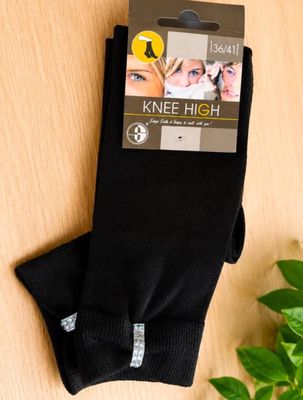 black knee high socks on a table with a plant in the background