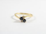 a close up of a gold ring with two black stones