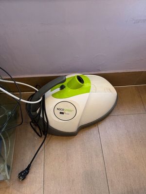 un aspirateur posé sur le sol à côté d'une poubelle