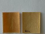 a close up of two pieces of gold paper on a white surface