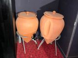 two orange pots sitting on stools next to each other