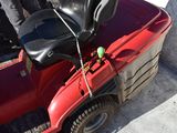 a red lawn mower parked on the side of the road