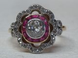 an image of a diamond and ruby ring on a table