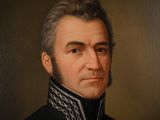 portrait of a man in a black coat with a chain around his neck