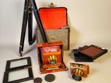 un appareil photo, un trépied, un miroir et quelques autres objets posés sur une table