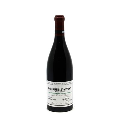 the bottle of red wine is sitting on a white surface