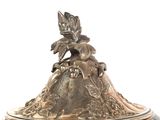 a silver plate with a lid that has a bird on it