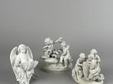 three white figurines of angels and angels on a table