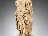 une statue en marbre blanc représentant une femme tenant un enfant dans ses bras