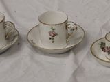 trois tasses et soucoupes sont posées sur une nappe blanche