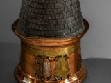 an image of a copper and black tower with a clock on top of it