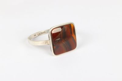 a silver ring with a tiger ' s eye stone in it