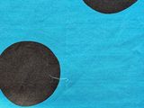 a close up of a blue and black polka dot fabric