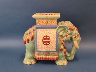 une figurine représentant un éléphant portant une boîte sur le dos