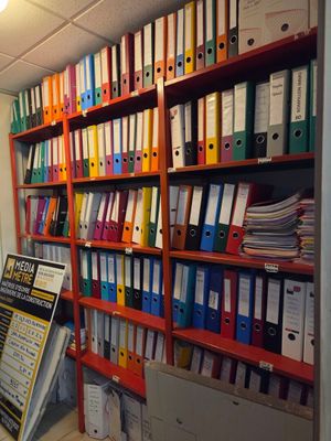 de nombreux dossiers sur les étagères de ce bureau