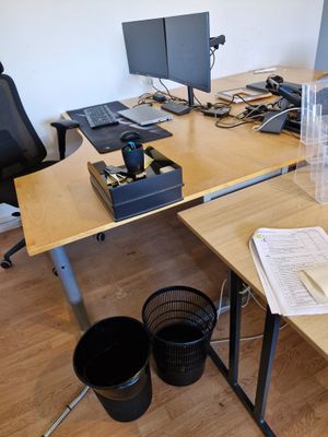 un bureau sur lequel se trouvent deux ordinateurs et une tasse