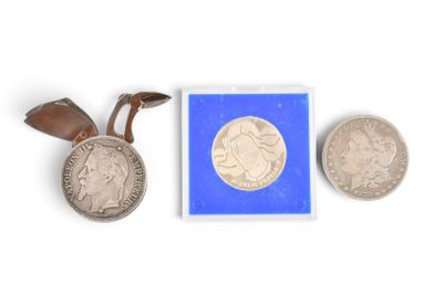 deux pièces d'argent et une petite pièce d'argent posées sur une surface blanche