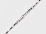 gros plan d'un bracelet en diamant sur une surface blanche
