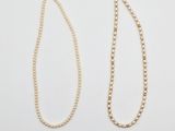a pair of pearl necklaces on a white background