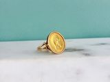 a gold coin ring sitting on top of a marble counter