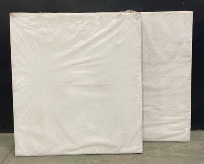 two white sheets of plastic sitting on top of a cement floor