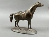 bronze statue of a horse with a saddle on it ' s back