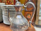 une théière en argent posée sur une table en bois