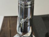 a silver bottle sitting on top of a wooden table