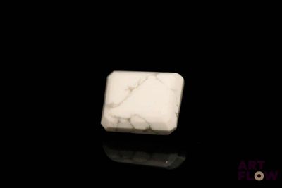 une photo d'un bloc de marbre blanc posé sur une surface noire