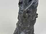 a statue of a man sitting on a tree trunk