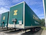 un gros camion vert garé sur le bord de la route