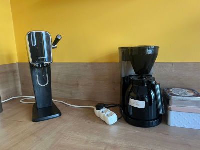 a coffee maker and a grinder sitting on a kitchen counter