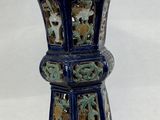 a blue vase sitting on a white surface with a white background