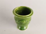 a green vase that is sitting on a white table
