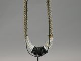 a black and white beaded necklace on a black stand